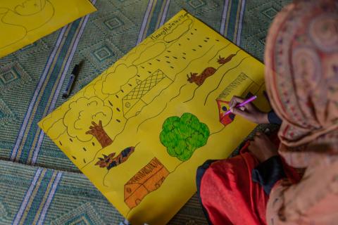 child drawing a house and a tree